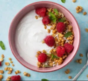 Yogurt in a bowl with raspberries.