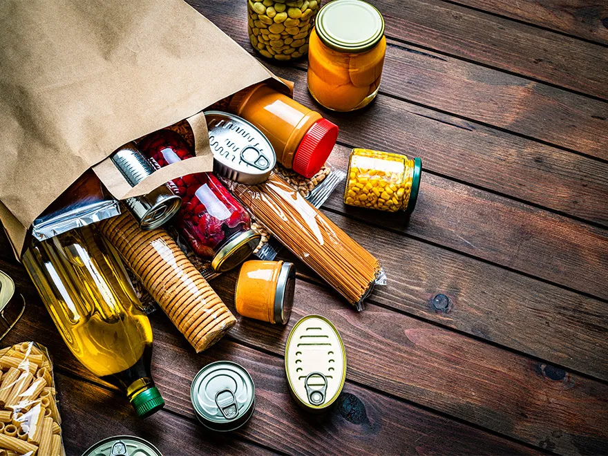 An overflowing grocery bag of fresh food items.