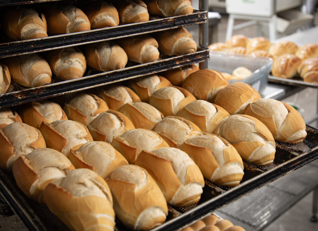 French bread on cooling racks in a bakery.