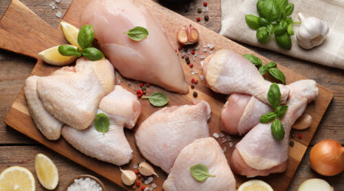 Meat and poultry products on a decorative cutting board.