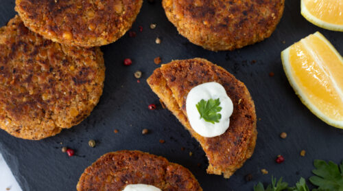 Spicy vegan burger patties with sour cream on dark background. Healthy plant-based meat alternative.