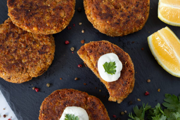 Spicy vegan burger patties with sour cream on dark background. Healthy plant-based meat alternative.